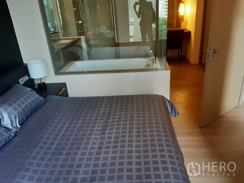 คอนโด ให้เช่าหรือขายในWatthana, Bangkok - ห้องนอนเชื่อมด้วยผนังกระจกไปยังห้องน้ำที่มีอ่างอาบน้ำและอ่างล้างหน้า