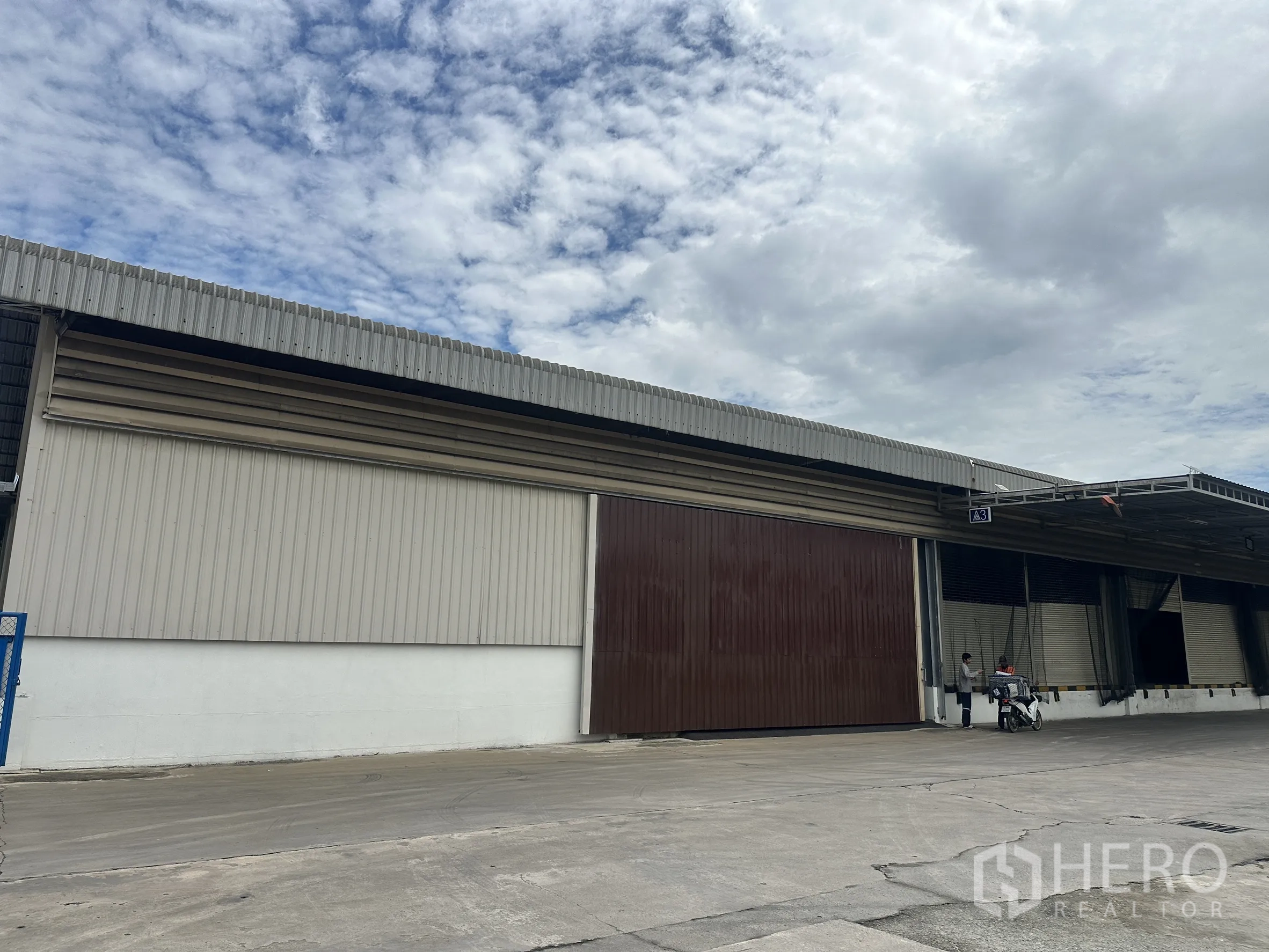 โรงงาน for rent in Lat Krabang, Bangkok - มุมข้างอาคารกรุเมทัลชีทพร้อมประตูบานเลื่อนสีน้ำตาลและกันสาด