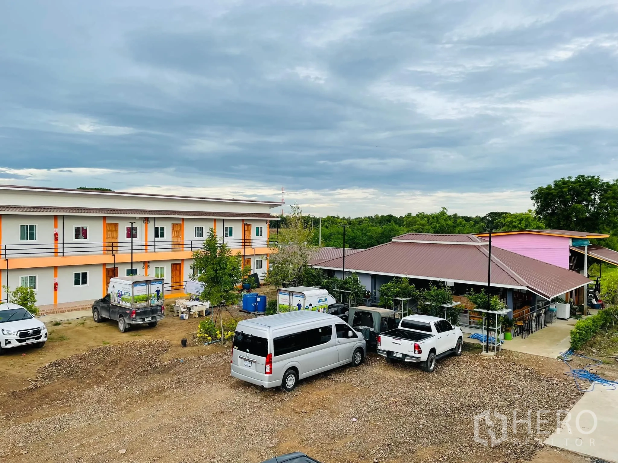 คลังสินค้า ให้เช่าหรือขายในPathum Thani - ลานจอดรถกว้าง มีรถตู้และกระบะหน้าอาคารหอพัก