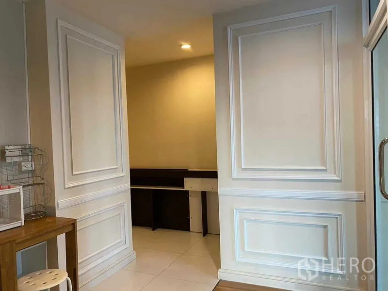 Condominium for rent in Pathum Wan, Bangkok - Entry area with decorative wall paneling opening to a compact study nook.