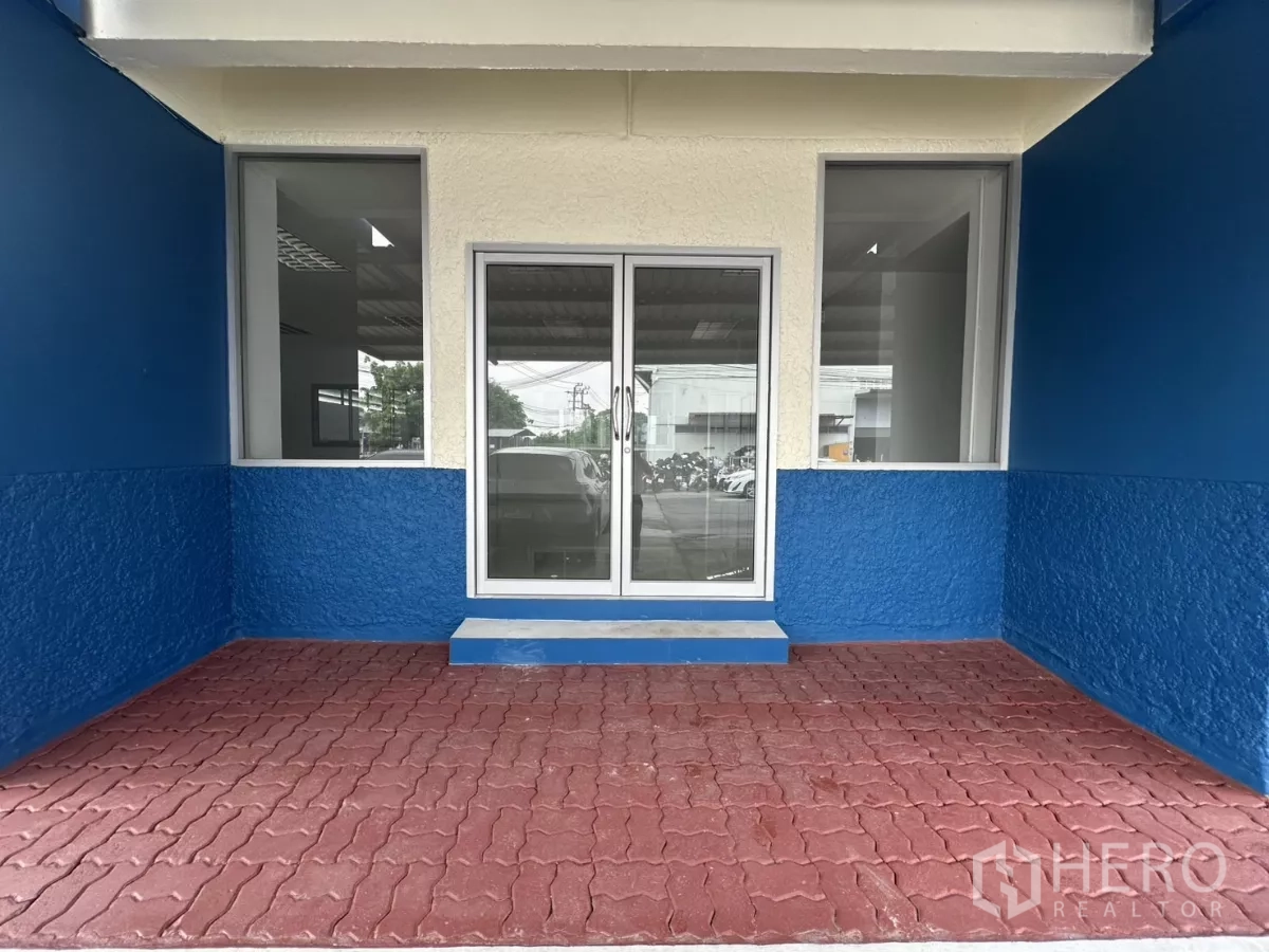 Factory for rent in Bang Phli, Samut Prakan - Front porch with sliding glass door and red paved entry.