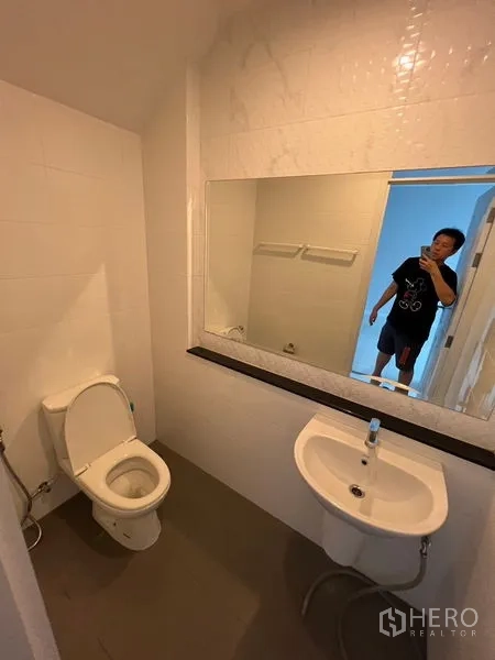 带办公室的家 出租或出售 - 客卫配坐便器、台盆和大镜面。