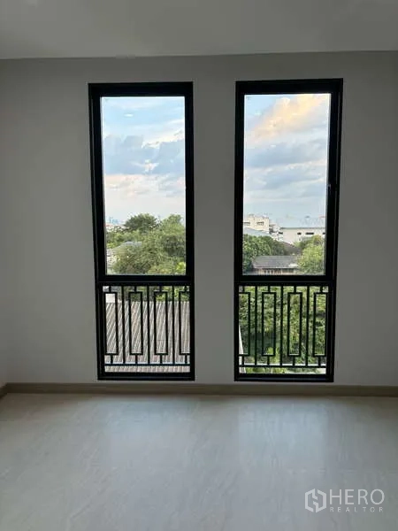 Detached House for rent or sale in Suan Luang, Bangkok - Tall paired windows framing city and treetop views from an upper floor