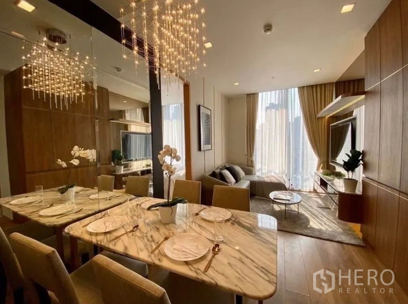 คอนโด ให้เช่าในWatthana, Bangkok - โต๊ะทานอาหารหินอ่อนใต้โคมไฟคริสตัล ผนังกระจก เชื่อมต่อห้องนั่งเล่นพร้อมหน้าต่างสูง