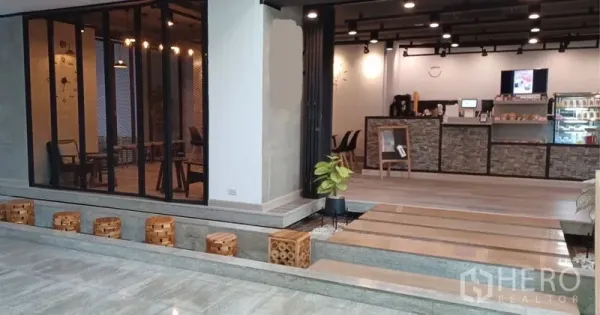 零售空间 出租在Khlong Toei, Bangkok - 开放式商铺空间，吧台收银区、台阶式步道、绿植与黑色轨道射灯。