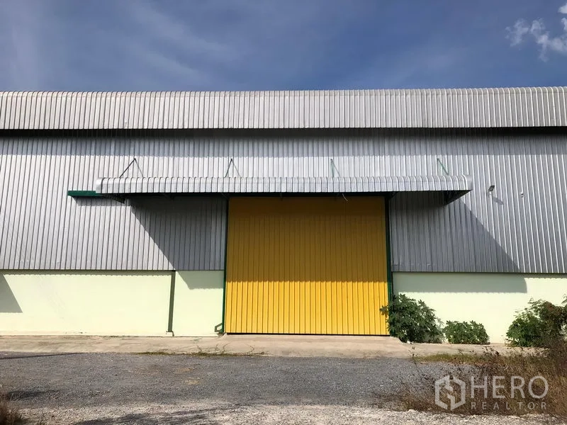 货栈 出租在Lat Krabang, Bangkok - 仓库正立面，宽大的黄色滑门与波纹金属墙面。