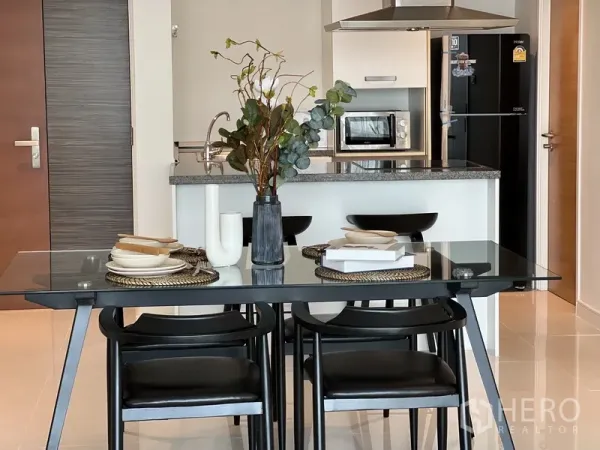 คอนโด ให้เช่าในWatthana, Bangkok - โต๊ะอาหารจัดเซ็ต หันสู่เคาน์เตอร์ครัว พร้อมไมโครเวฟและตู้เย็น