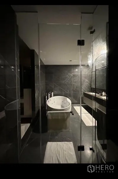 独立式住宅 出租 - 现代卫浴，深色石材，玻璃隔间，中心摆放独立式浴缸.