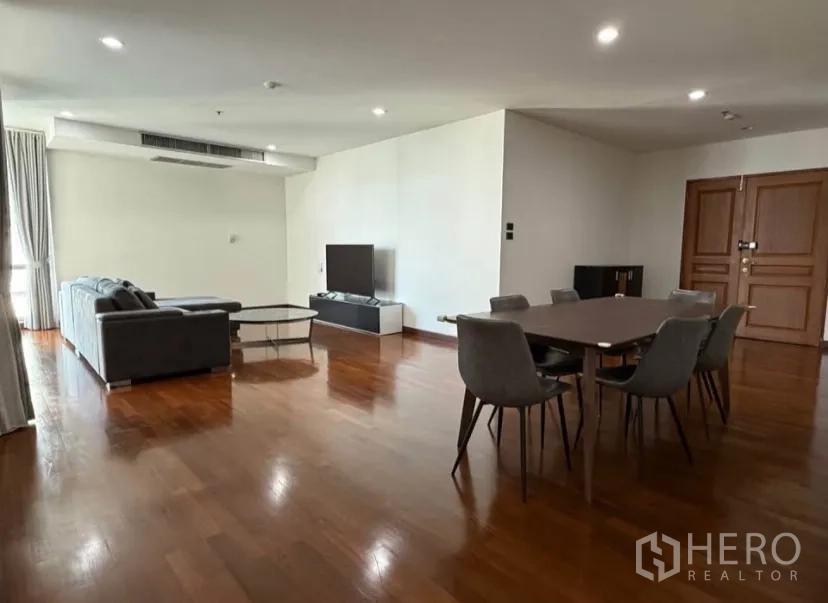 คอนโด for rent in Pathum Wan, Bangkok - ห้องนั่งเล่นและรับประทานอาหารกว้างขวางพร้อมโซฟาสีเทา ทีวี และโต๊ะอาหารหกที่นั่ง