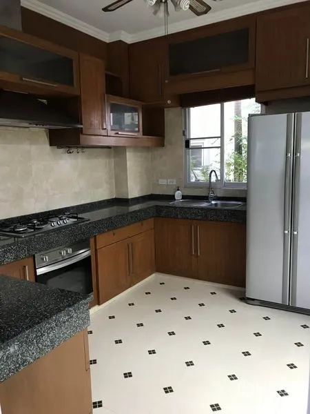 บ้าน ให้เช่าในKhlong Toei, Bangkok - ห้องครัวรูปตัวแอล เคาน์เตอร์หินแกรนิต เตาแก๊ส ตู้ไม้ และตู้เย็นสองประตู