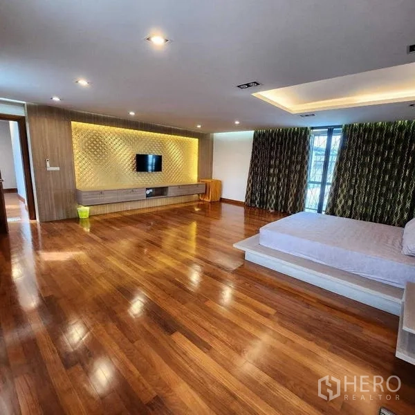 บ้าน ขายในPhra Khanong, Bangkok - ห้องนอนมาสเตอร์ขนาดใหญ่ พื้นไม้ ผนังตกแต่งไฟซ่อน และตู้วางทีวี