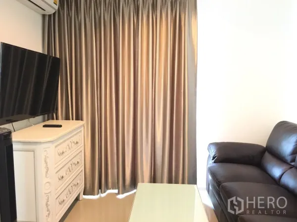 คอนโด ให้เช่าในKhlong Toei, Bangkok - ห้องนั่งเล่นโซฟาหนัง ทีวีบนตู้ลิ้นชัก และผ้าม่านเต็มความสูง