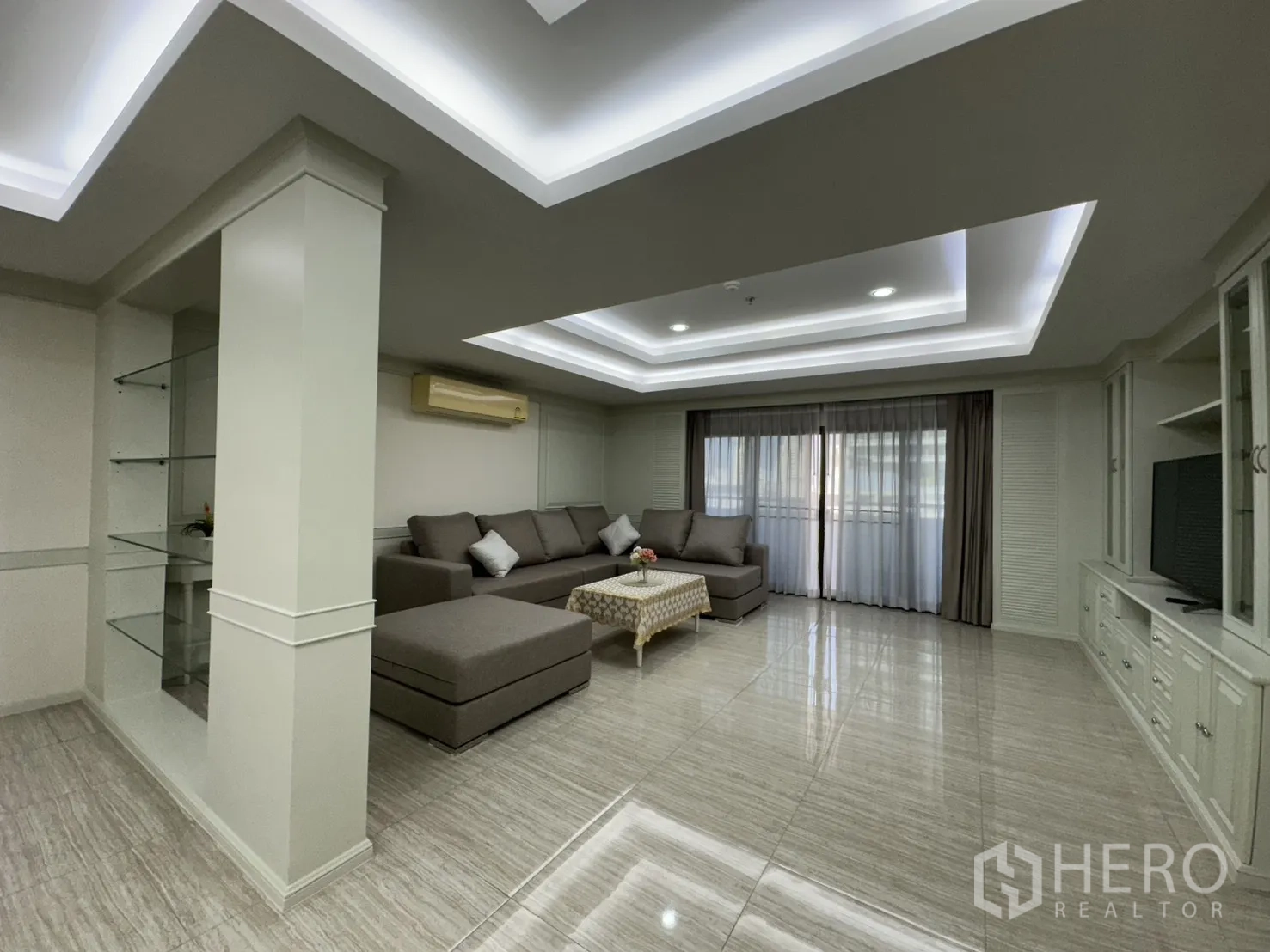 Condominium for rent in Watthana, Bangkok - Large open-plan living area with glossy floors and built-in TV cabinetry.