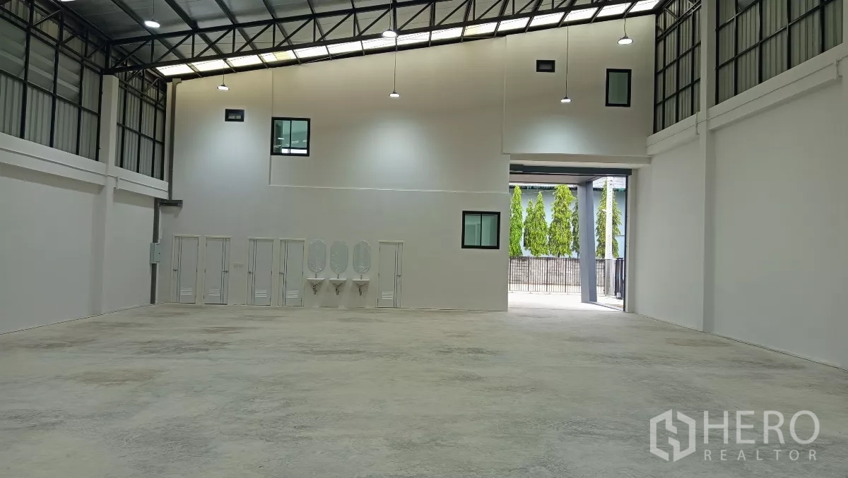 货栈 出租或出售在Lam Luk Ka, Pathum Thani - 仓库内部朝向卷闸门，可见洗手台与多间卫生间。