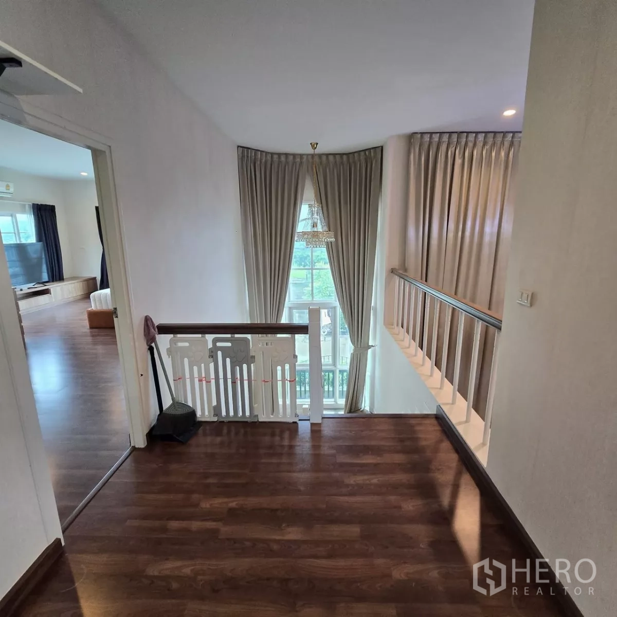 บ้าน ให้เช่าในMueang Pathum Thani, Pathum Thani - โถงชั้นบนเห็นโคมระย้าและหน้าต่างสูงของห้องนั่งเล่น