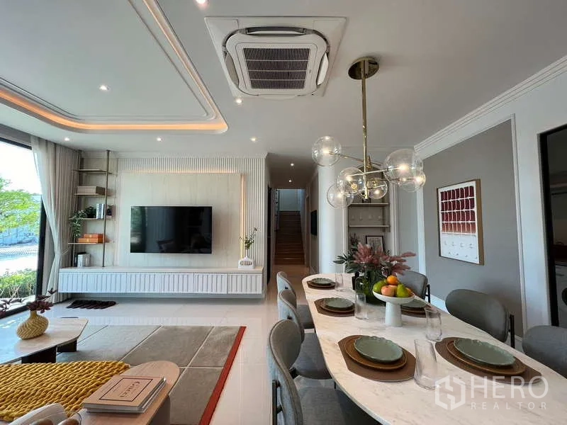 Detached House for sale in Saphan Sung, Bangkok - Dining room view toward the staircase and TV wall beneath cassette ceiling AC.