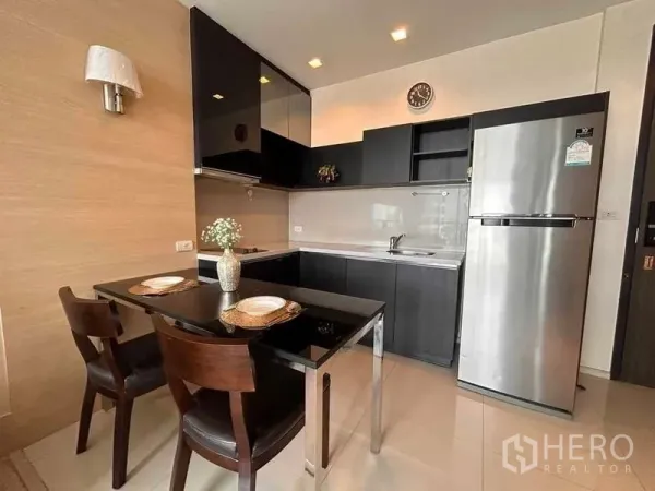 คอนโด ให้เช่าหรือขายในKhlong Toei, Bangkok - ครัวรูปตัวแอลตู้สีดำ พร้อมโต๊ะทานข้าวและตู้เย็นสแตนเลส