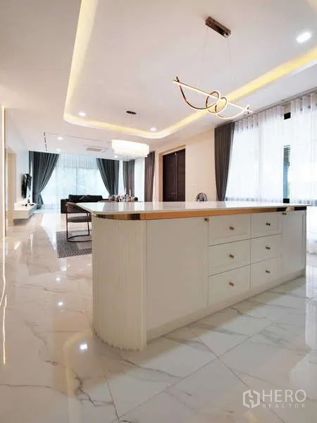 Detached House for rent or sale in Thanyaburi, Pathum Thani - Wide view of island counter and open-plan layout with cove lighting and sheer drapes.