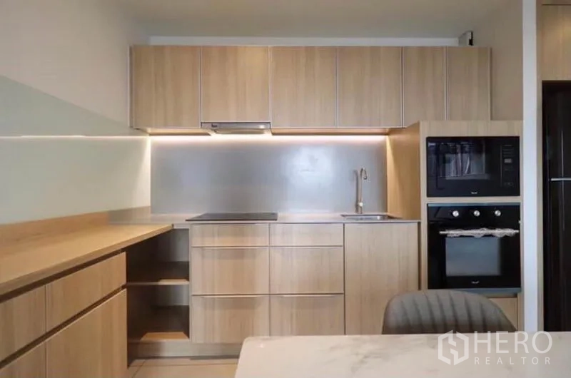 คอนโด ให้เช่าในWatthana, Bangkok - ภาพระยะใกล้ของครัวมินิมอล เตาแม่เหล็กไฟฟ้า อ่างล้างจาน และไฟใต้ตู้