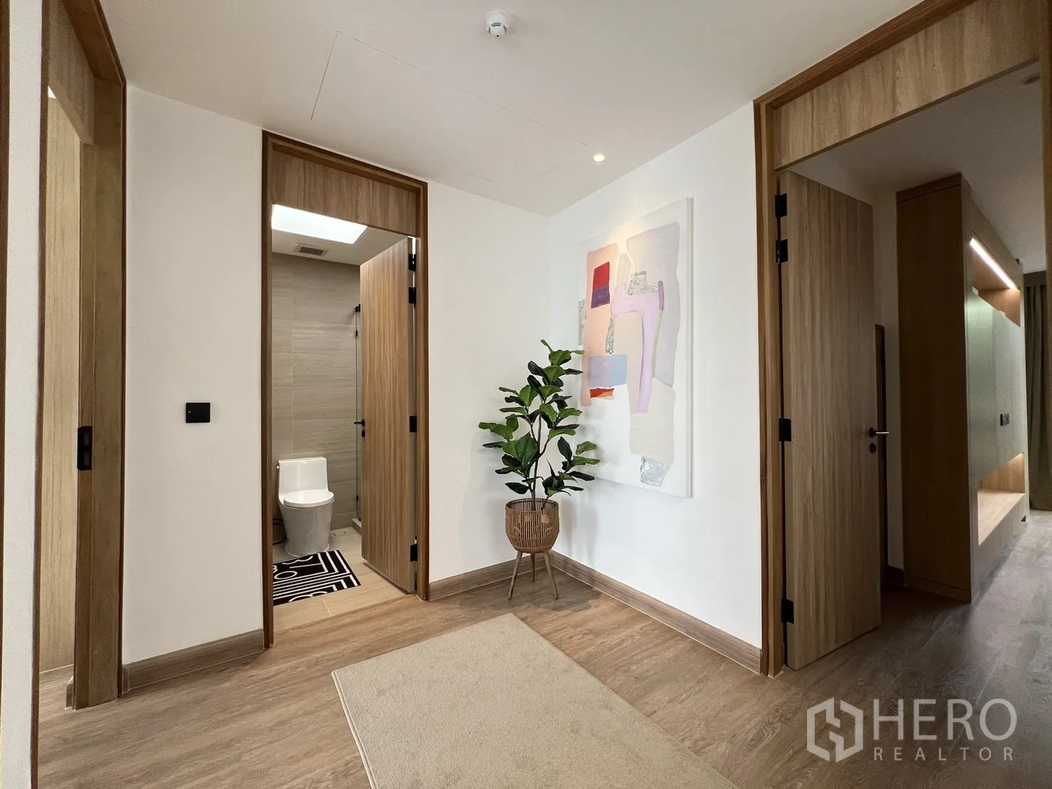 Townhouse for sale in Watthana, Bangkok - Primary bedroom with slatted feature wall, window seat and garden view.