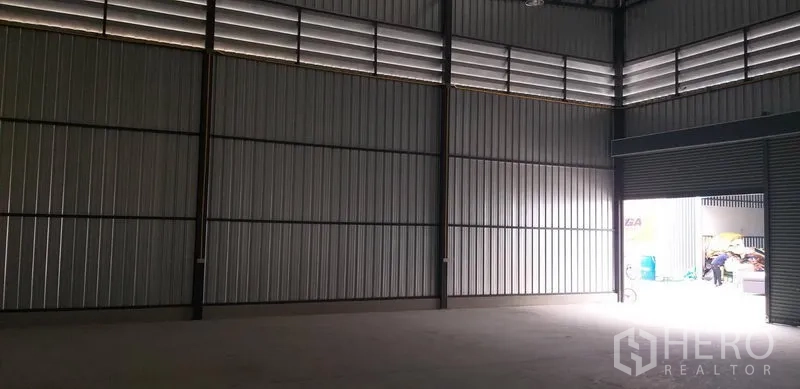 货栈 出租在Bang Phli, Samut Prakan - 空置仓库内部，高挑层高，通风百叶与大型卷帘门。
