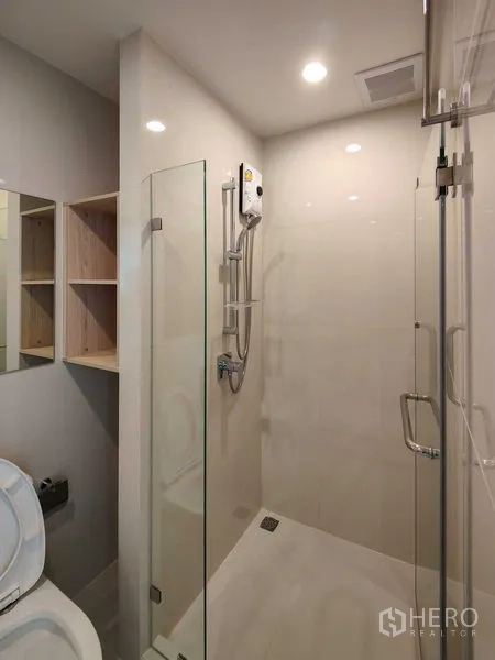 Condominium for rent - Modern bathroom with glass shower enclosure, handheld shower and recessed lighting.