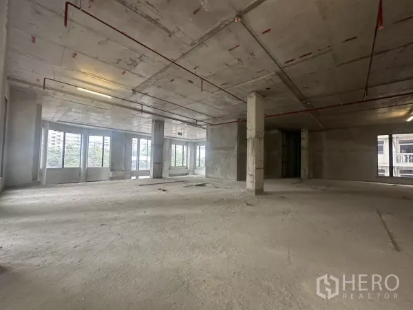 零售空间 出租在Watthana, Bangkok - 明亮转角区，大片玻璃与城市绿景，空置商铺壳体。