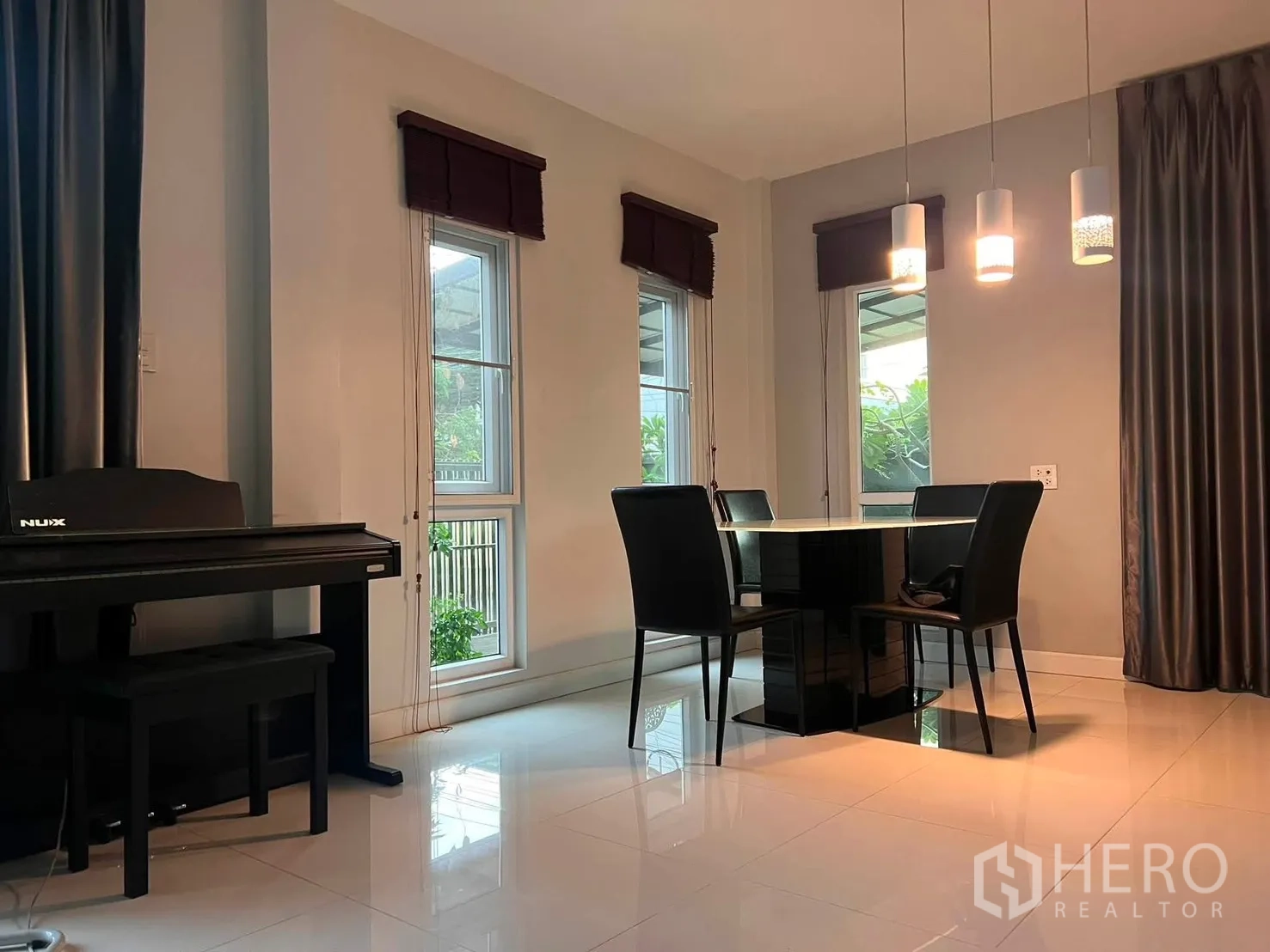 Detached House for rent in Watthana, Bangkok - Dining corner with pendant lights, a four-seat table, and a digital piano by the window.