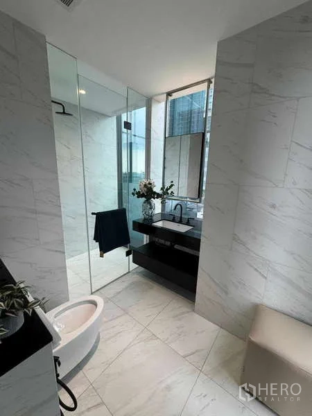 公寓 出租在Bang Rak, Bangkok - 明亮大理石卫浴，玻璃淋浴间与洗手台，带窗景