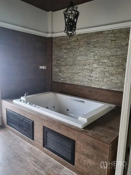 Townhouse for rent in Wang Thonglang, Bangkok - Spa-style room showcasing a sunken jacuzzi tub and stone accent wall.