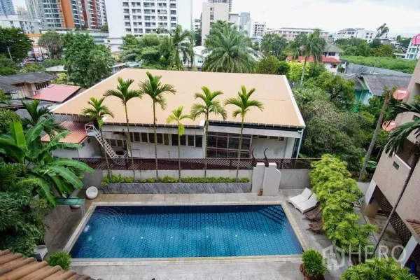 อพาร์ทเมนท์ ให้เช่าในWatthana, Bangkok - สระว่ายน้ำกลางแจ้งล้อมด้วยต้นปาล์มและอาคารโลว์ไรส์