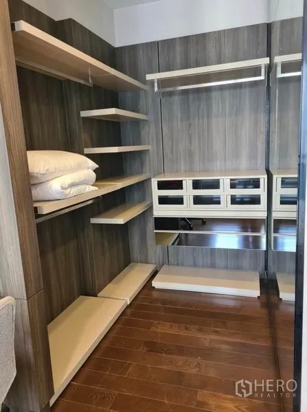 Condominium for rent or sale in Huai Khwang, Bangkok - Walk-in closet with shelves, drawers and hanging space in wood finish.
