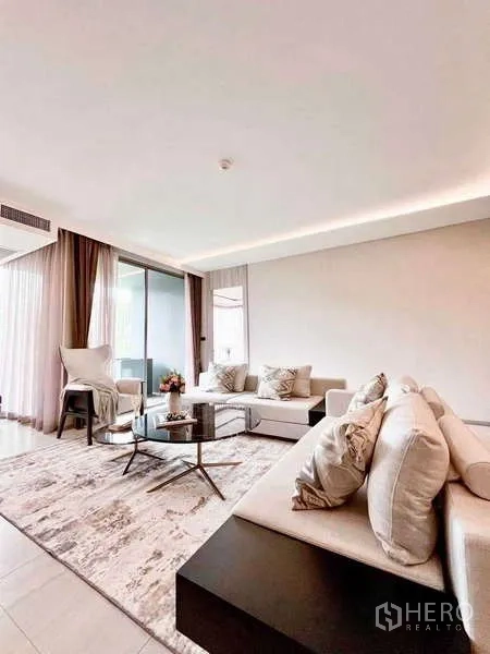 คอนโด ให้เช่าในWatthana, Bangkok - ห้องนั่งเล่นโปร่งโล่ง มีโซฟาคู่ โต๊ะกลาง และประตูกระจกบานเลื่อนไปยังระเบียง