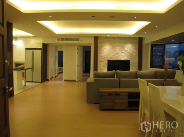 Condominium for rent in Watthana, Bangkok - Open-plan lounge and dining area with cove lighting, TV feature wall and city views.