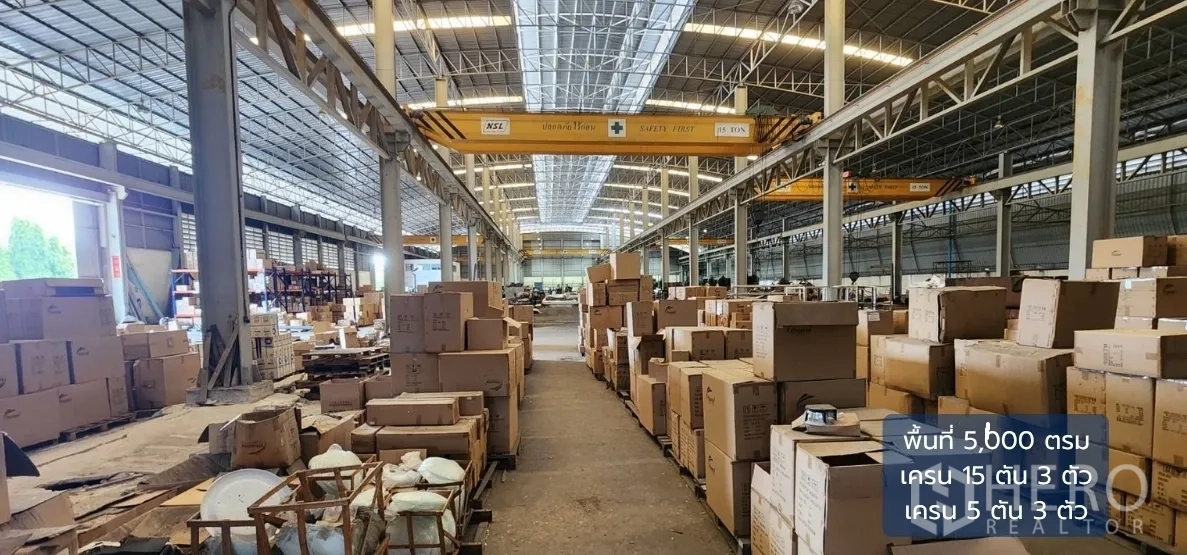 Factory for rent in Bang Phli, Samut Prakan - Central aisle of the warehouse lined with materials beneath multiple overhead cranes.
