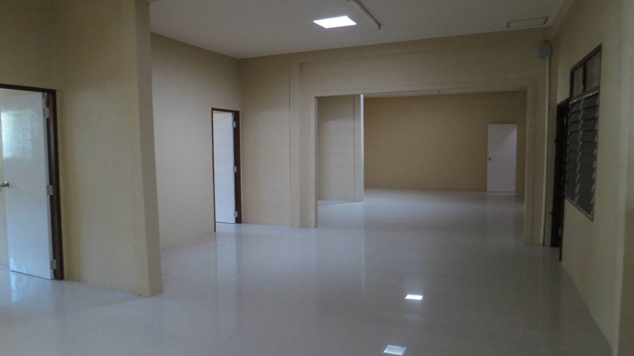 Warehouse for rent in Wang Thonglang, Bangkok - Long open office corridor with partitioned rooms and glossy tile flooring.