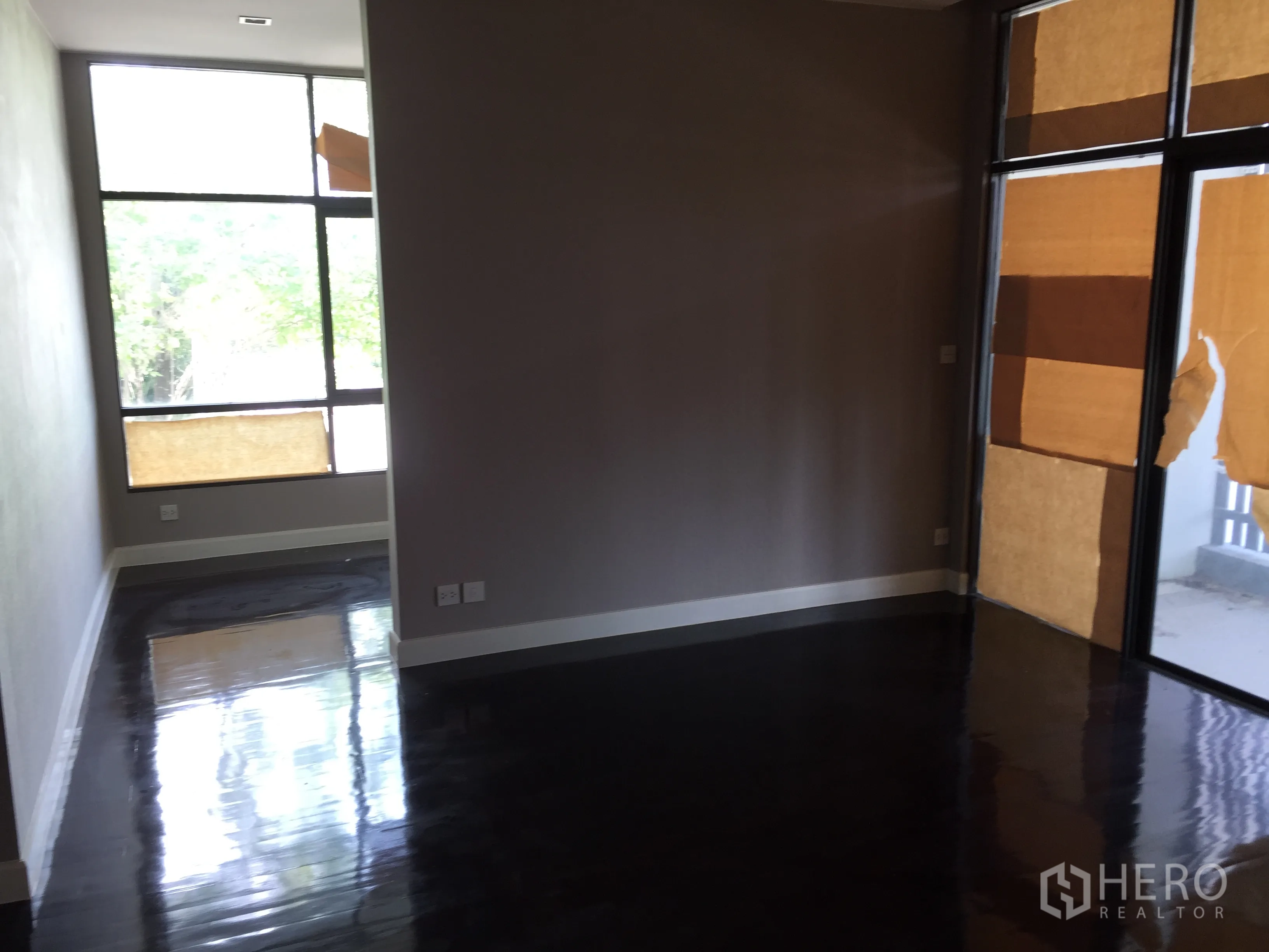 Detached House for rent or sale in Bang Kapi, Bangkok - Upstairs multipurpose room with tall windows and access to a terrace.