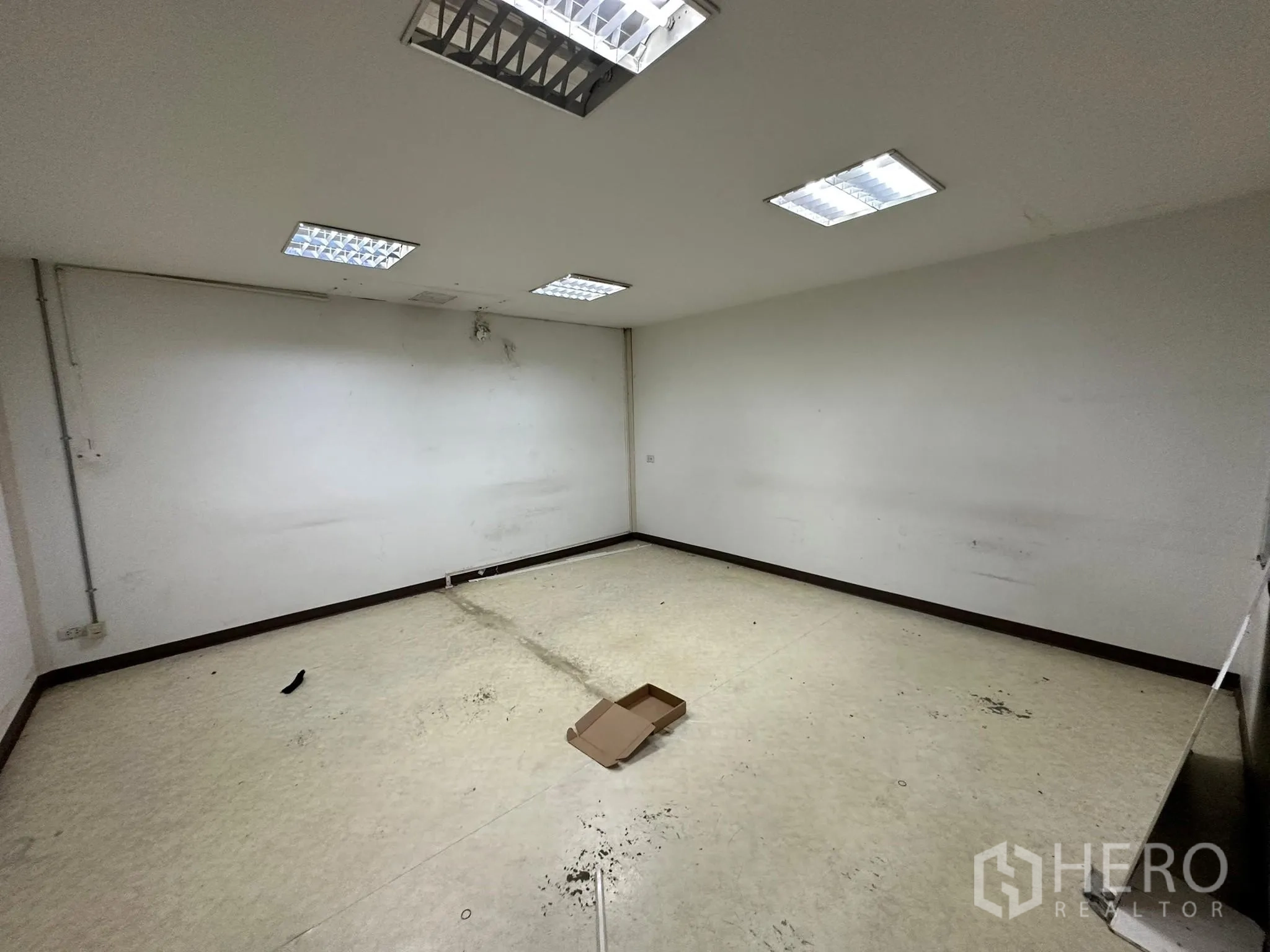 Warehouse for rent in Huai Khwang, Bangkok - Empty room with vinyl flooring suitable for private office or storage.