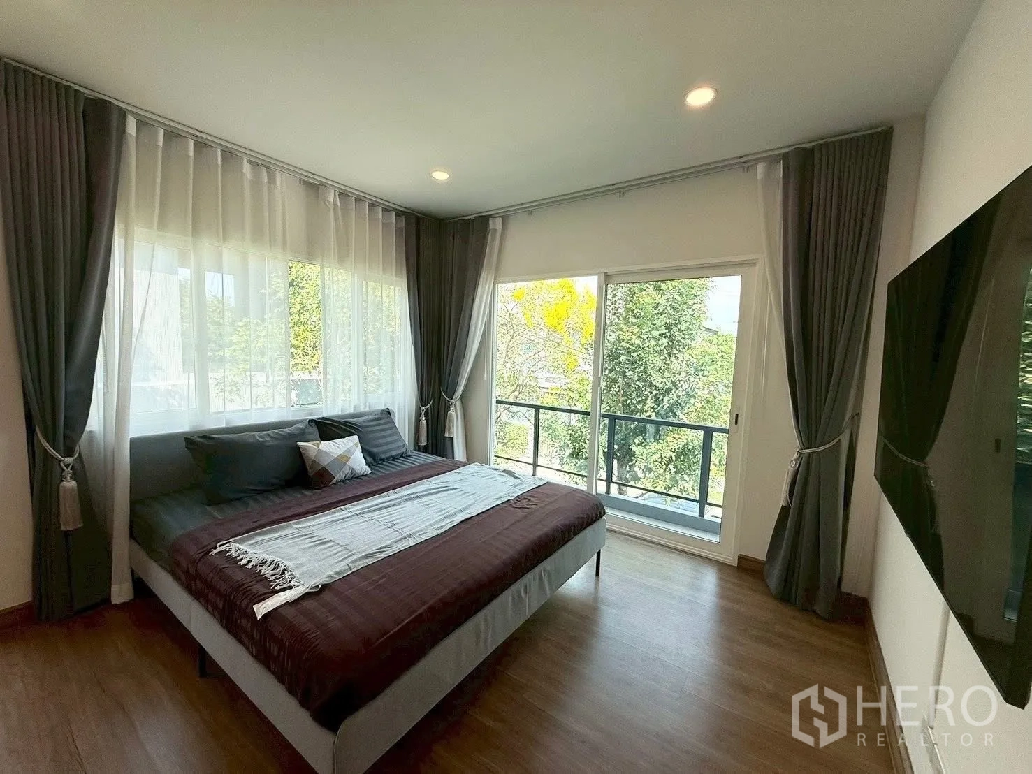 Detached House for rent in Prawet, Bangkok - Corner bedroom with king bed, balcony doors and garden views.