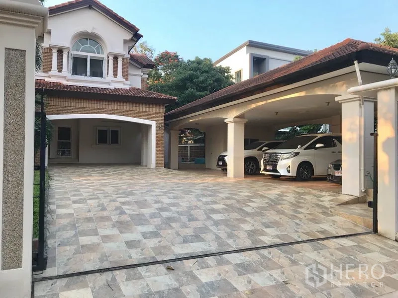 独立式住宅 出租 - 宽阔铺砖车道，拱形顶棚下的多车位车库。