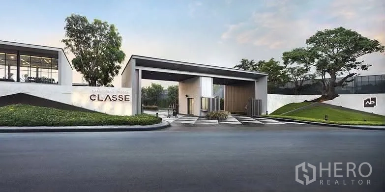 Townhouse for rent in Lat Phrao, Bangkok - Modern gated entrance of the residential community with signage and landscaping.