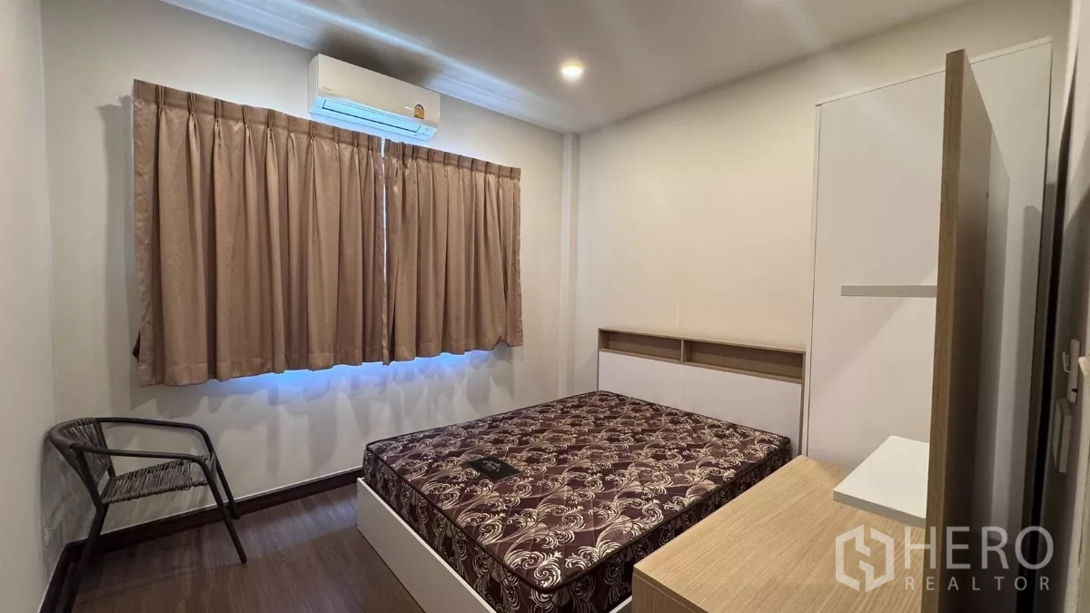 บ้าน ให้เช่าหรือขายในSaphan Sung, Bangkok - อีกมุมของห้องนอนพร้อมเตียง เครื่องปรับอากาศ และหน้าต่างติดผ้าม่าน พื้นไม้.