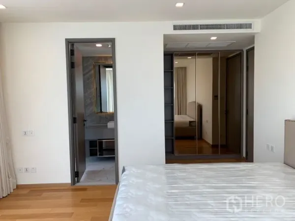 Condominium for sale in Khlong Toei, Bangkok - Bedroom with ensuite access and built-in mirrored wardrobe.