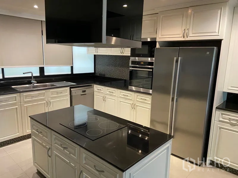 คอนโด ขายในKhlong San, Bangkok - ครัวสีขาวทันสมัย ท็อปหินแกรนิตสีดำ ไอส์แลนด์เตาไฟฟ้า และเครื่องใช้สแตนเลส