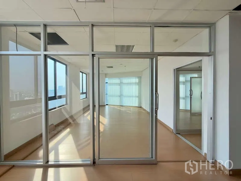 办公空间 出租在Chatuchak, Bangkok - 推拉玻璃门通向明亮会议室，城市景观与百叶窗。