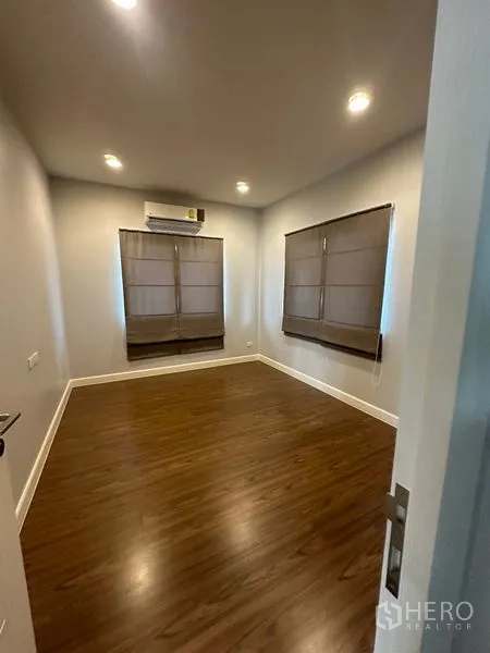 บ้าน ให้เช่าหรือขายในLam Luk Ka, Pathum Thani - ห้องนอนโล่ง พื้นไม้ ม่านมู่ลี่ และเครื่องปรับอากาศติดผนัง