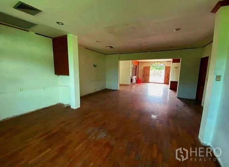 独立式住宅 出售在Prawet, Bangkok - 宽敞客厅，木地板与大窗户，室内采光好