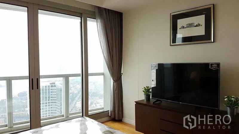 คอนโด ให้เช่าในKhlong San, Bangkok - ห้องนอนพร้อมตู้วางทีวีและประตูกระจกบานเลื่อนออกสู่ระเบียงวิวเมือง
