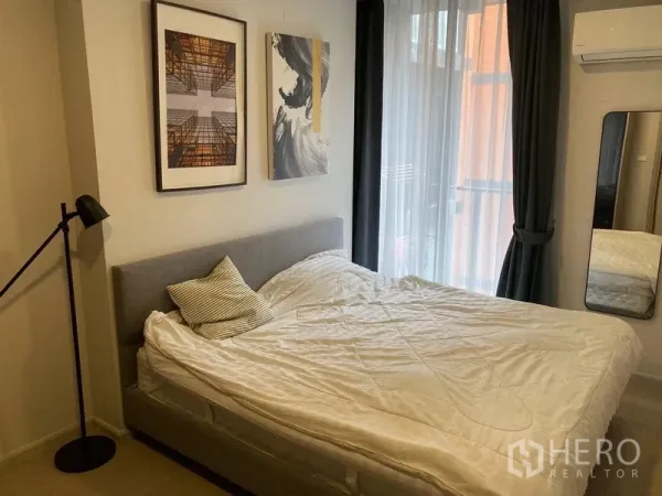 公寓 出租在Khlong Toei, Bangkok - 温馨卧室，双人床、装饰画并可通往阳台。