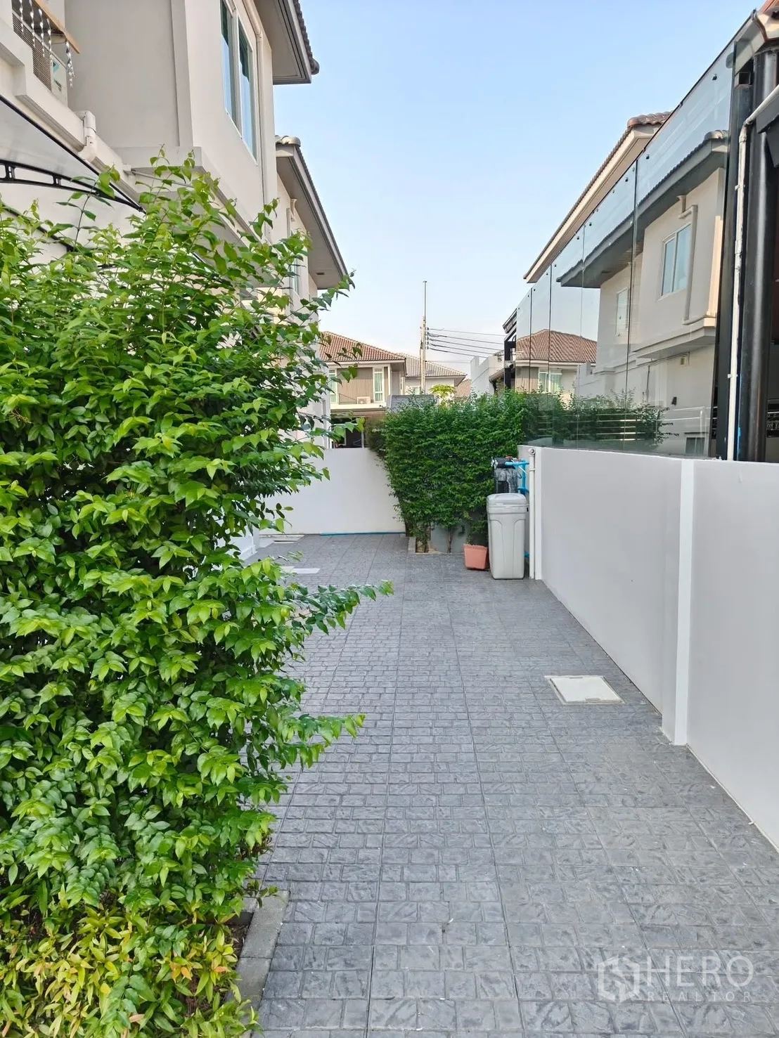 独栋房屋 for rent or sale in Bang Phli, Samut Prakan - 两侧绿篱环绕的铺砖侧院通道。